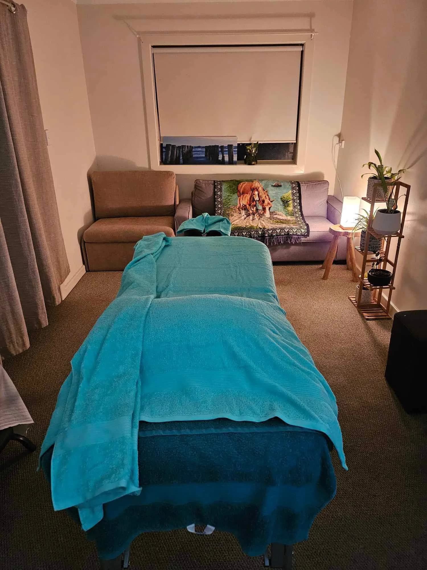 Massages By Sarah treatment room in Port Pirie — massage table set up with fresh towels, soft lamp light and indoor plants